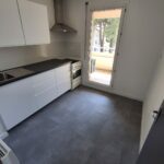 Cuisine neuve avec façades blanches et hotte inox après rénovation à Blagnac