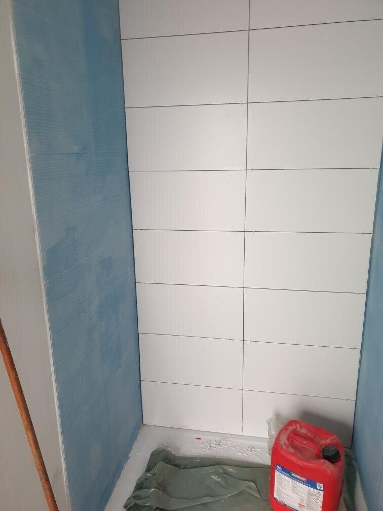 Pose de la faïence de la douche sur panneaux d'étanchéité pendant les travaux à Saint-Orens-de-Gameville