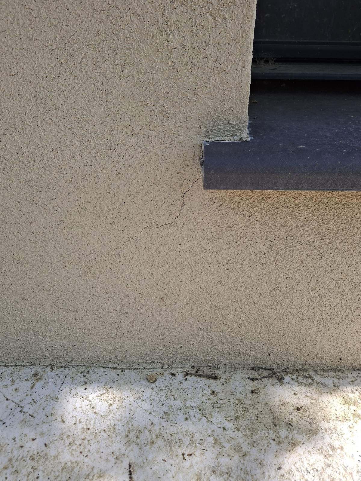 Fissure en escalier dans le crépi à l'angle d'une baie, désordre lié à la sécheresse, à Belflou