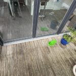 Terrasse bois vieillie devant une baie du dernier étage avant travaux à Toulouse