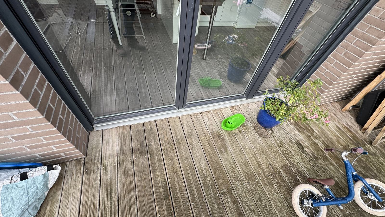 Terrasse bois vieillie devant une baie du dernier étage avant travaux à Toulouse