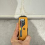 Mesure d'humidité au testeur sur la faïence de la salle d'eau lors d'une recherche de fuite à Toulouse