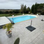 Vue d'ensemble de la piscine et de sa plage carrelée avant travaux à Encausse