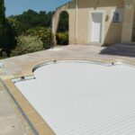 Plage de piscine neuve autour du bassin, équipements conservés, après travaux à Encausse