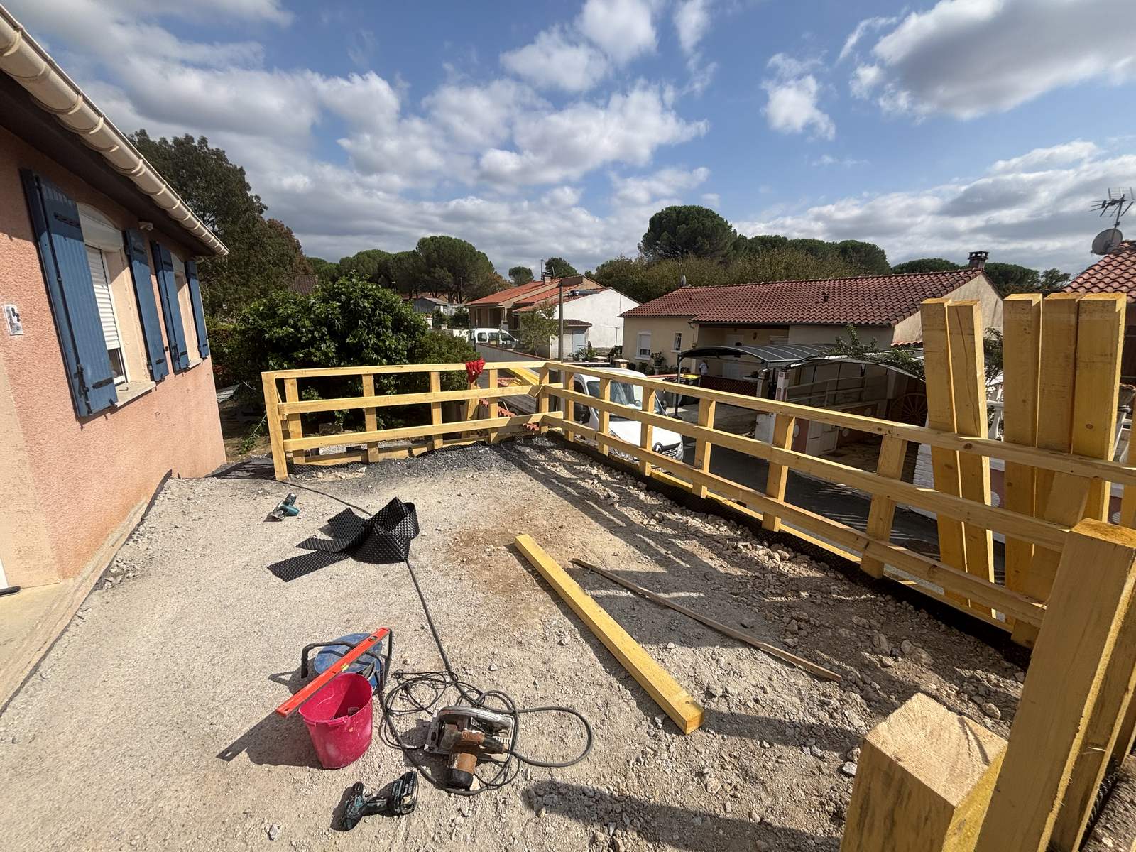 Plateforme remblayée et nivelée avec rambarde bois en place pendant les travaux à Castres