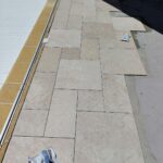 Pose du carrelage en opus sur la plage de piscine pendant les travaux à Encausse
