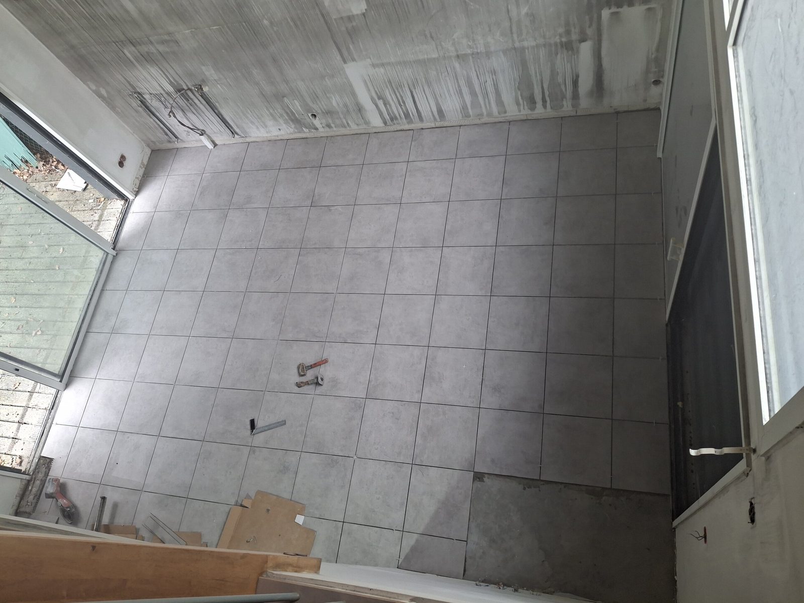 Pose du nouveau carrelage au sol pendant les travaux à Saint-Orens-de-Gameville