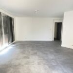Séjour entièrement rénové, sol vinyle gris et murs blancs, après travaux à Blagnac