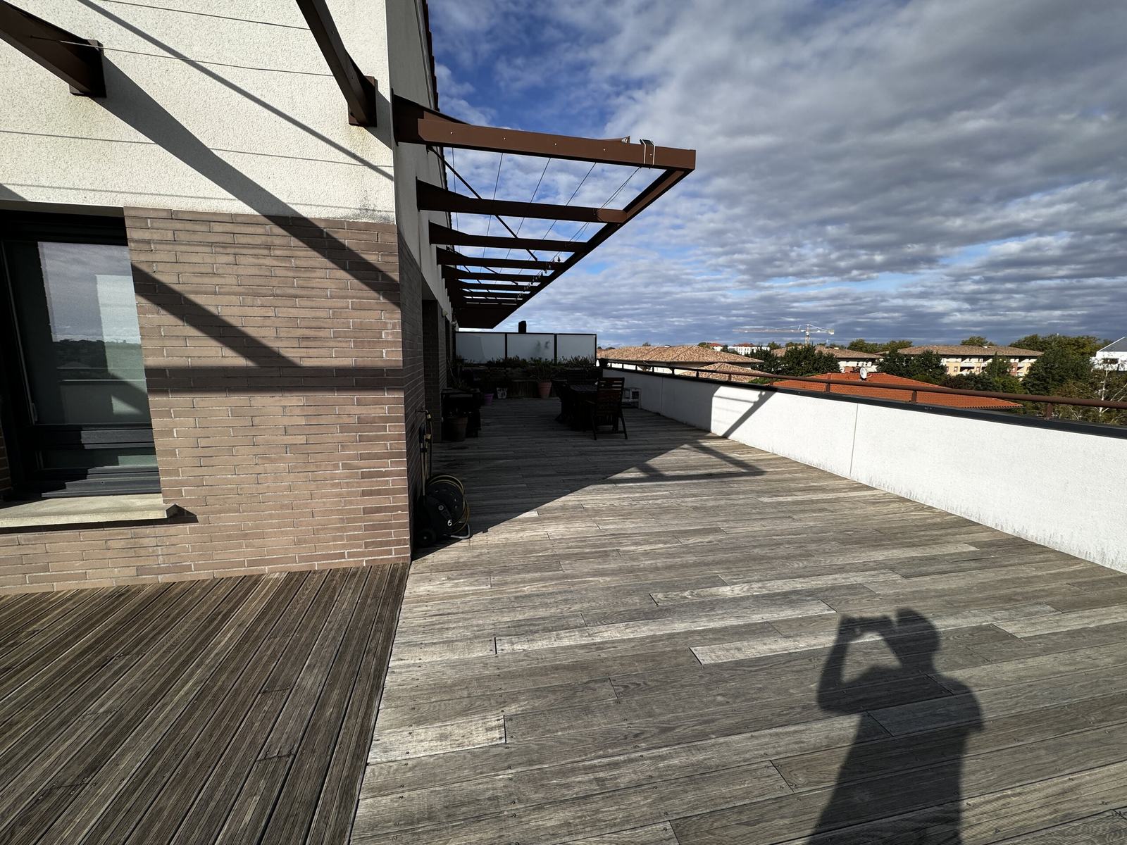 Terrasse bois grisée sous la pergola du dernier étage avant travaux à Toulouse
