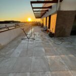 Terrasse neuve en dalles sur plots au coucher du soleil en fin de chantier à Toulouse