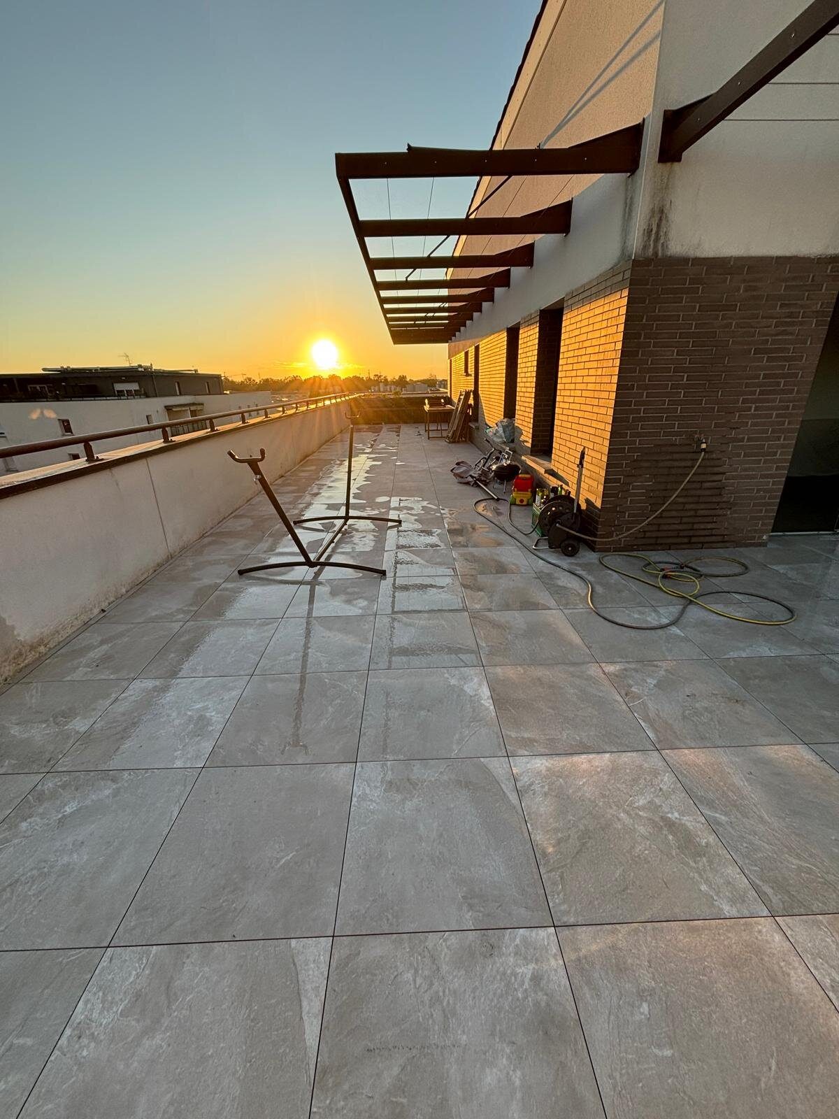 Terrasse neuve en dalles sur plots au coucher du soleil en fin de chantier à Toulouse